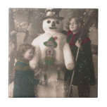 Carreau Photo de Christmas Girls et Snowman Vintage<br><div class="desc">Une charmante carte postale de Noël 1910 française de deux jolies et adorables petites filles qui s'embrassent et posent avec leur ami bonhomme de neige festif,  alors que la neige flotte sur elles.</div>