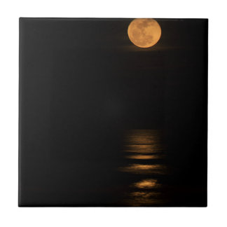 Carreau pleine lune d'or au-dessus d'océan