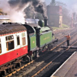 CARREAU TRAINS À VAPEUR<br><div class="desc">Un train à vapeur magnifiquement restauré et des chariots d'une époque révolue quittant la gare et le conducteur du moteur passe la clé avant d'être autorisé à continuer le long du chemin de fer. Angleterre Royaume-Uni.</div>