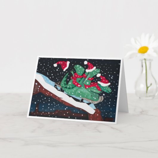 Carte A whimsical holiday card with sledding dinosaurs (Petite plante)
