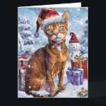 Carte Abyssinian Chat Winter Wonderland Noël Joie<br><div class="desc">Ce design festif reflète l'esprit joyeux de la période des fêtes, avec un adorable petit portant un chapeau de Père Noël. Le chat est niché dans un pays des merveilles hivernales, avec un bonhomme de neige, un sapin de Noël décoré et des cadeaux joliment emballés. Les flocons de neige tombent...</div>