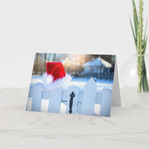 Carte Chapeau de Père Noël sur une clôture blanche à pic