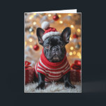 Carte Chien de Noël Français avec chapeau de Père Noël<br><div class="desc">Un bulldog français noir en chandail rayé rouge et blanc est posé sur un tapis en fourrure blanche. Le texte peut être modifié.</div>