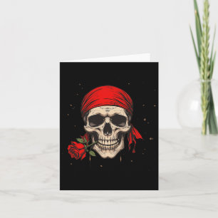 Carte Crâne de pirate et os entrecroisés main fleur roug