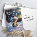 Carte de Noël Cute Dragon<br><div class="desc">En utilisant les puns "Père Noël "Claws" arrive en ville" et "il va découvrir qui est le feu et la glace" cette carte a un humour subtil et est aussi un design mignon avec un Dragon avec de grands yeux se préparant pour Noël.</div>