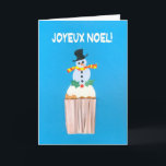 Carte de Noël, Français, Cupcake avec Snowman<br><div class="desc">Une carte de Noël française lumineuse et joyeuse avec un bonhomme de neige décoré et un saint sur un cupcake glacé, d'un collage de papier peint à la main par Judy Adamson. L'accueil avant, en texte blanc sur un arrière - plan bleu, est "Joyeux Noel !" et le message intérieur,...</div>