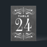 Carte de numéro de table à l'ancienne avec fioritu<br><div class="desc">Un travail de défilement blanc orné et une typographie vintage ressortent sur un fond sombre de tableau noir sur cette charmante carte de numéro de table de mariage. Les fioritures dessinées à la main et les lettrages classiques apportent une élégance rustique à la disposition des sièges de votre réception. Le...</div>