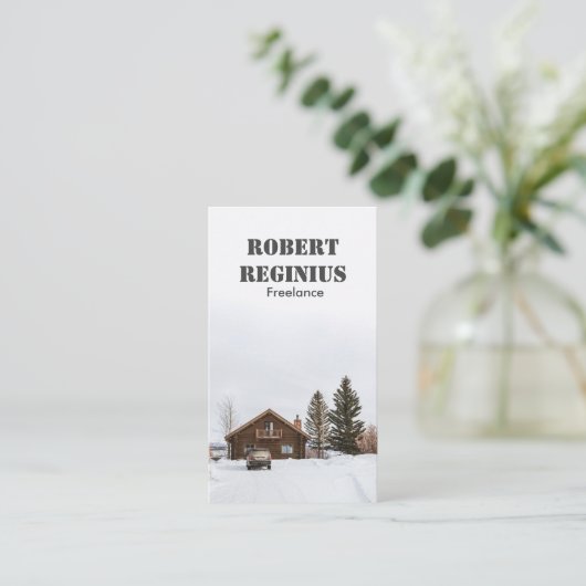 Carte De Visite maison en bois marron sur terrain recouvert de nei (Debout devant)