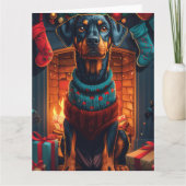 Carte Doberman avec des cadeaux de Noël devant une chemi (Devant)