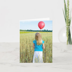 Carte fille dans le champ de blé avec ballon rouge