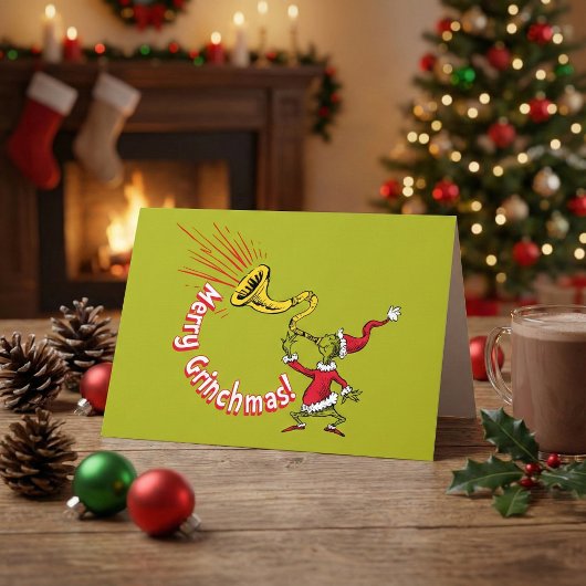Carte Grinch soufflant dans la corne joyeuse de Grinchma