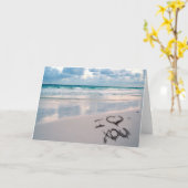 Carte Je t'aime, écriture de sable sur la plage (Fleur jaune)