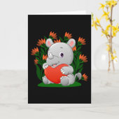 Carte le bébé rhino tient le ballon de couleur du coeur (Fleur jaune)