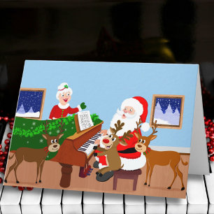 Carte Père Noël jouant du piano avec couverture de renne