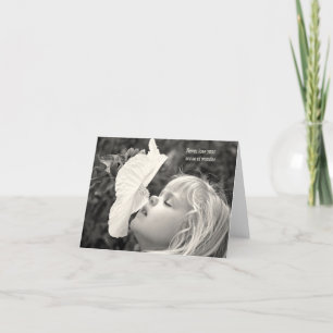 Carte petite fille blonde qui renifle un hibiscus