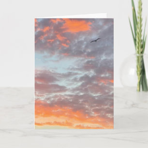 Carte Photo d'oiseau volant dans un ciel aux nuages rose