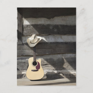 Carte Postale Cowboy casquette sur guitare s'appuie sur le cabin