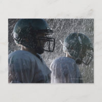 Deux joueurs de football américains sous la pluie,