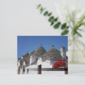 Carte Postale Fleurs de géranium et maisons de trulli à Alberobe (Debout devant)