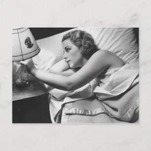 Carte Postale Jeune femme allongée sur le lit éteint la lampe