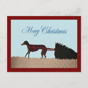 Carte Postale Lévrier tirant un arbre de Noël à travers la neige