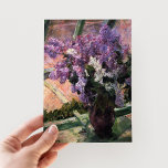 Carte Postale Lilacs dans une fenêtre | Mary Cassatt<br><div class="desc">Lilacs in a Window (1880) de Mary Cassatt est un délicat tableau en natation qui présente un vase rempli de lilas vibrants placé près d'une fenêtre. L'oeuvre capture la beauté des fleurs fraîches et la lumière douce qui filtre à travers le verre, évoquant un sentiment de tranquillité. L’attention minutieuse accordée...</div>