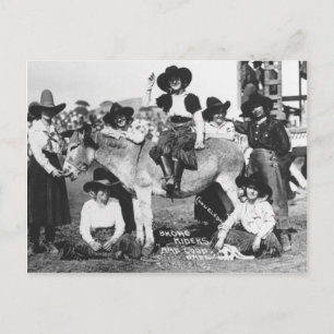 Carte Postale Seven rodeo cowgirls jokingly posing with a donkey