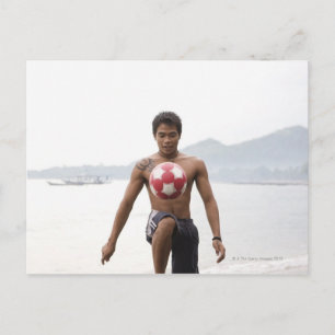 Carte Postale Un mec joue au football sur la plage