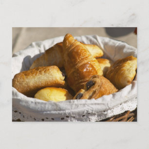 Carte Postale Un panier petit-déjeuner en osier avec croissants.