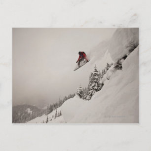 Carte Postale Un snowboardeur saute d'une falaise dans de la pou