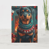 Carte Rottweiler avec des cadeaux de Noël devant une che (Devant)