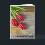 Carte Souhaits de l'anniversaire de l'ami avec les<br><div class="desc">Tulipes rouges avec des gouttelettes d'eau sur le bois pour l'anniversaire de l'ami.</div>