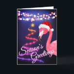 Cartes Pour Fêtes Annuelles Flamant rose rose Festive Tropical Beach Noël<br><div class="desc">Cette carte de voeux de Noël tropicale Bonnes Fêtes de plage comporte un flamant rose portant un chapeau de Père Noël rouge et blanc. Il y a des lampes à cordes festives et un arbre de Noël Ribbon et Stars. Salutation Intérieure ~ "Les Voeux Les Plus Chauds De Notre Paradis...</div>