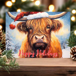 Cartes Pour Fêtes Annuelles Highland Cow Santa Hat Joli Noël<br><div class="desc">Célébrez la saison des Fêtes avec cette adorable carte de Noël avec une charmante vache des Highlands portant un chapeau de Père Noël. La scène festive comprend des arbres enneigés et un accueil joyeux "Happy Holidays" en rouge. Parfait pour ajouter une touche de fantaisie et de chaleur à vos salutations...</div>