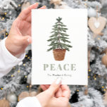 Cartes Pour Fêtes Annuelles Paix Simple Arbre À feuillage persistant de Noël<br><div class="desc">Cette simple carte postale de vacances présente une aquarelle illustrant un arbre à feuillage persistant dans un panier. Le mot "PAIX" apparaît dans de grandes lettres de sauge vert qui se coordonnent avec l'art. Ajoutez le nom de votre famille et l'année en italique gris charbon, et votre adresse de retour...</div>