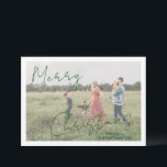 Cartes Pour Fêtes Annuelles Photo moderne Vert rustique Script élégant Noël<br><div class="desc">Carte de Noël photo moderne avec un design simple et minimal avec "Joyeux Noël" dans un script élégant et rustique sur votre photo préférée avec votre nom de famille. Le modèle comprend une superposition blanche pour aider le texte à se démarquer sur votre photo et peut être supprimé dans l'outil...</div>