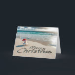 Cartes Pour Fêtes Annuelles Snowman de Noël tropical sur une plage<br><div class="desc">Un bonhomme de neige de sable portant un chapeau de Père Noël se dresse sur une plage de sable avec "Joyeux Noël" écrit dans le sable</div>