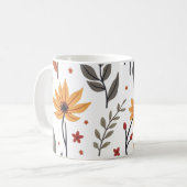 C'est une tasse décorée de fleurs et de feuilles. (Devant gauche)