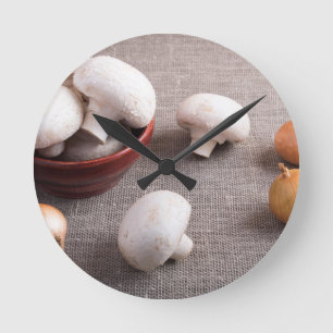 Champignon-paddenstoelen en uien op tafel ronde klok