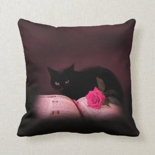 chat noir avec le coussin de livre et de rose