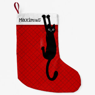 Chat noir s'accrochant à une chaussette de Noël am