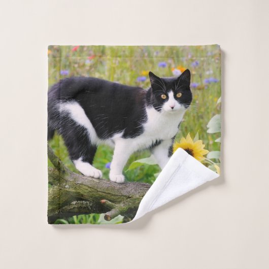 Chat tuxedo mignon sur une branche d'arbre avec de (Gant de toilette)