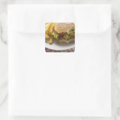 Cheeseburger, gebitten, met chips vierkante sticker (Tas)