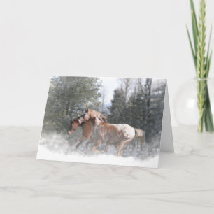 Chevaux courant dans la carte de Noël neige