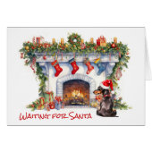 Chien noir Dachshund attend la cheminée Père Noël (Devant horizontal)