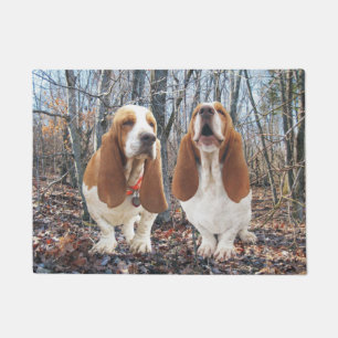Chiens de basset dans le tapis de porte en bois