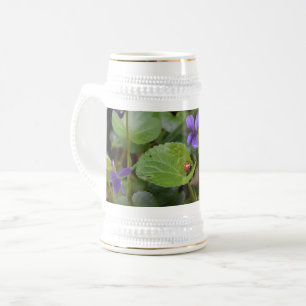 Chope À Bière Ladybug sur les fleurs de violet doux