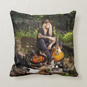 Chris Caffery assis avec un oreiller de guitare