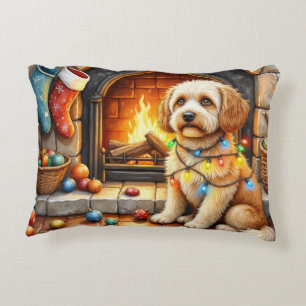 Cockapoo zit bij de open haard met kerstlicht accent kussen