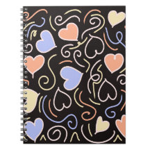 Cœurs de couleur claire sur un cahier de fond noir